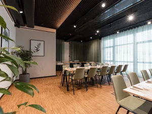 Zeller’s Quartier: das besondere Tagungshotel in Bayern Moderner Konferenzraum mit Holzboden, Stühlen und großen Fenstern mit Vorhängen