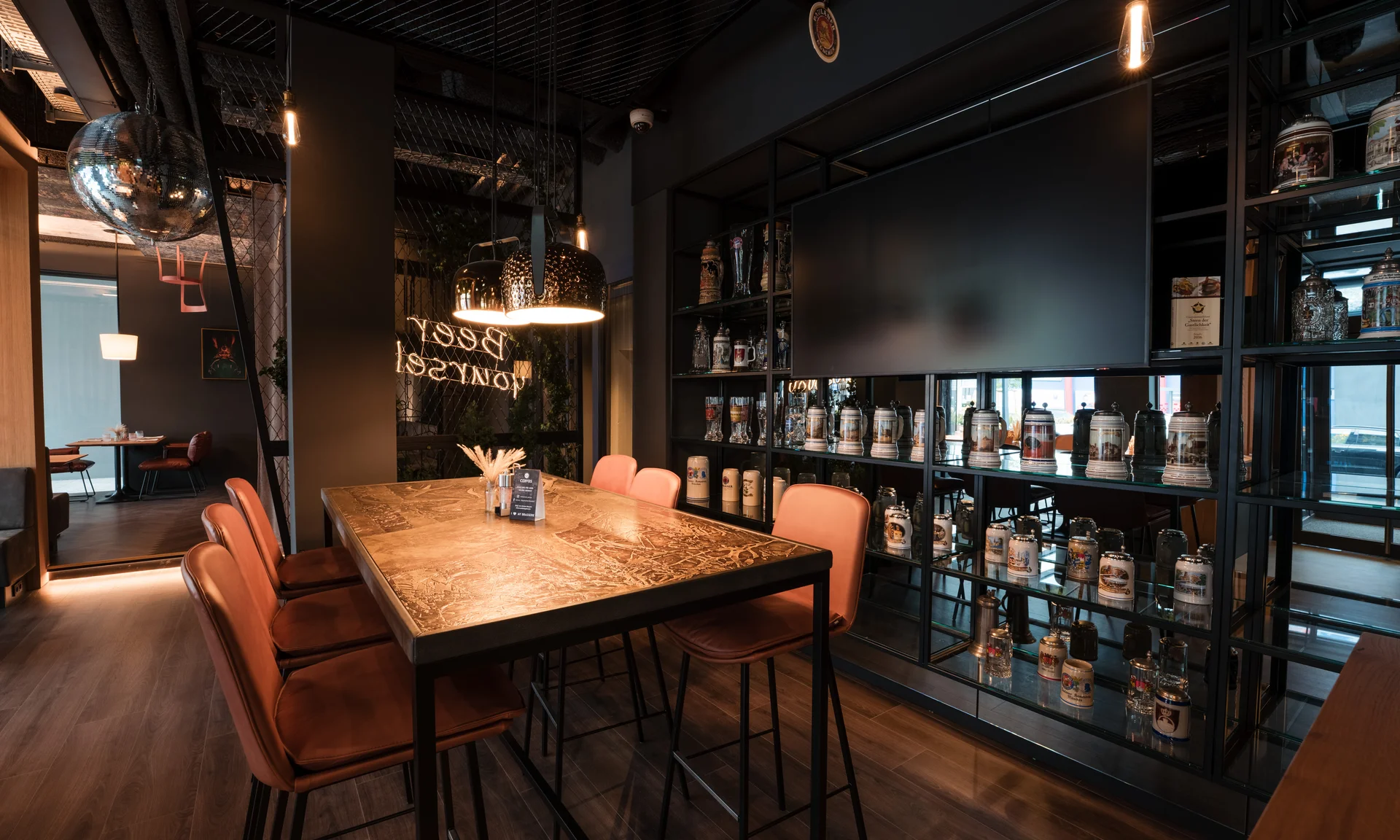 Moderner Gastraum mit Bartisch, Ledersesseln und dekorativen Bierkrügen an der Wand