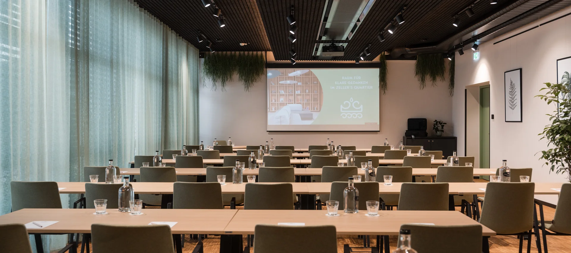 Helles Seminarzimmer mit grünen Stühlen und grünen Vorhängen Helles Seminarzimmer mit grünen Stühlen und grünen Vorhängen