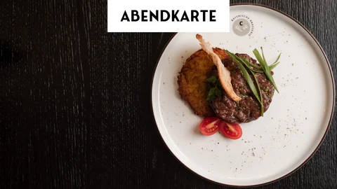Abendessen mit Kartoffelpuffer, Rindfleisch und Tomate auf weißem Teller