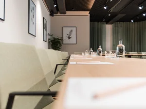 Zeller’s Quartier: das besondere Tagungshotel in Bayern Moderner Konferenzraum mit langen Tischen, Stühlen und Wasserflaschen