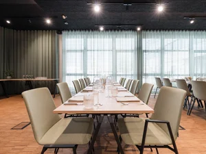 Zeller’s Quartier: das besondere Tagungshotel in Bayern Moderner Speiseraum mit gedecktem Tisch und beigen Stühlen vor großen Fenstern