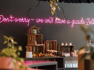 Zeller’s Quartier: das besondere Tagungshotel in Bayern Neonlicht mit Aufschrift Don't worry we will have a guade Zeit an einer Wand