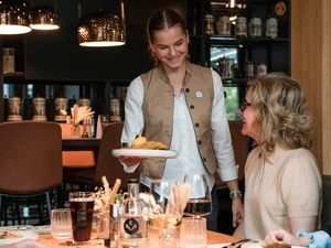 Kellnerin serviert einem Gast in einem Restaurant ein Gericht