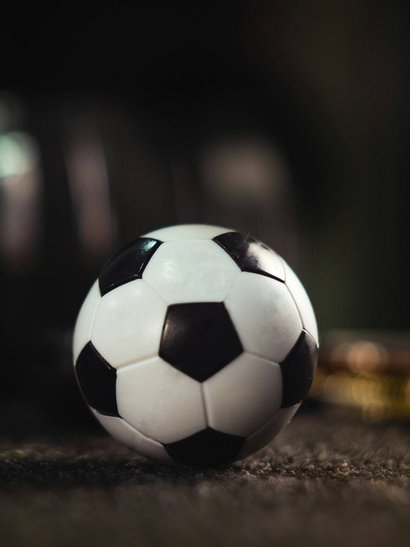 Zeller’s Quartier: Hotel Nähe Messe Augsburg und München Nahaufnahme eines schwarz-weißen Fußballs auf einem dunklen Boden