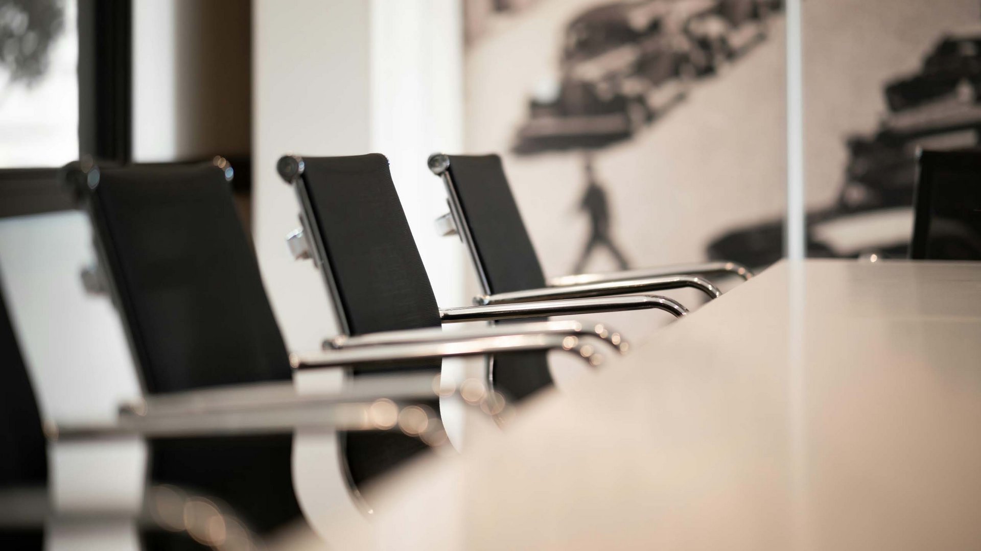 Leere schwarze Bürostühle neben einem weißen Konferenztisch