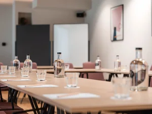 Zeller’s Quartier: das besondere Tagungshotel in Bayern Konferenzraum mit Holztisch, Wasserflaschen und Gläsern, moderne Einrichtung