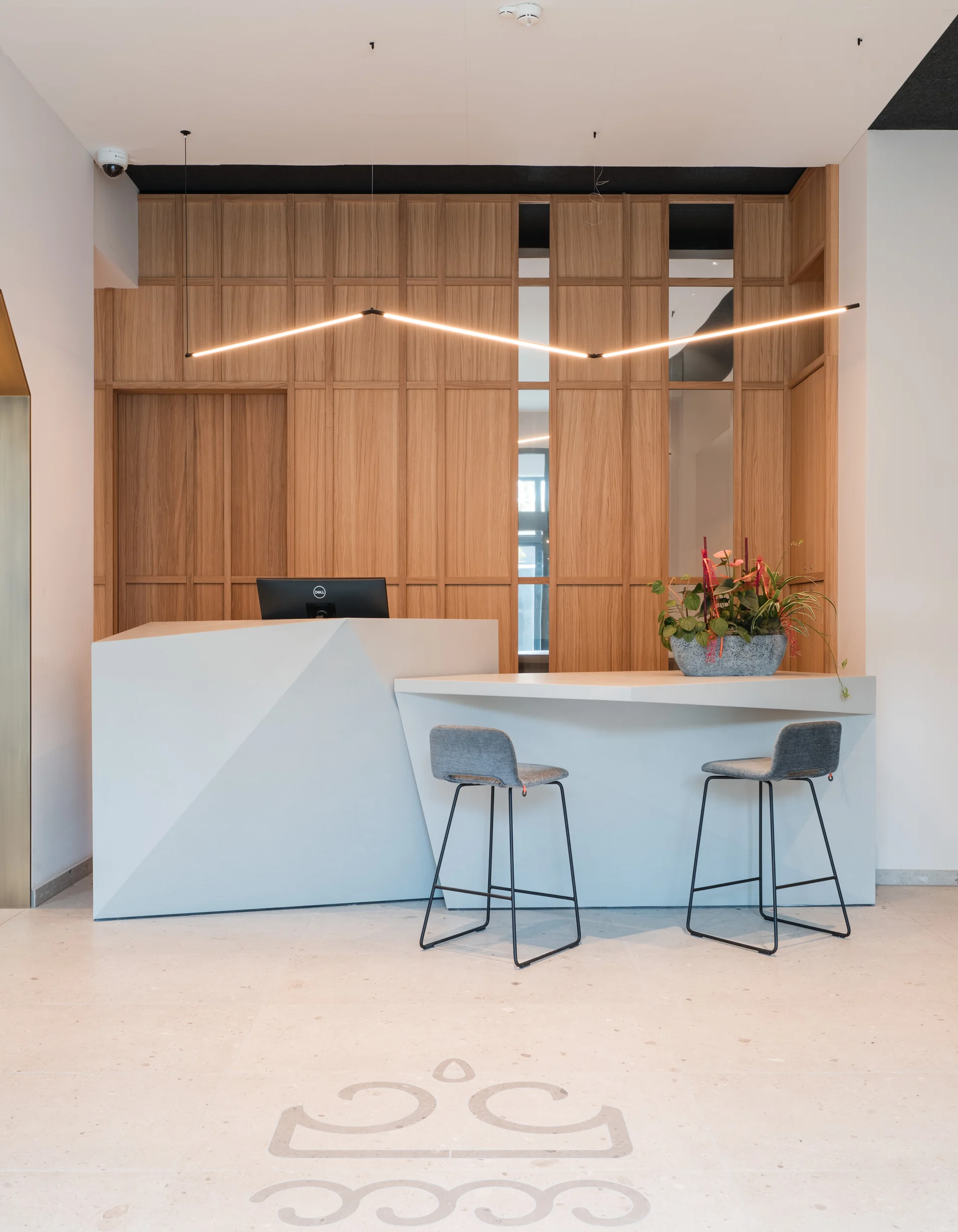 Moderner Empfangsbereich mit Holzpaneelen und minimalistischer Rezeption