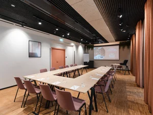 Zeller’s Quartier: das besondere Tagungshotel in Bayern Moderner Konferenzraum mit U-förmigen Tischen und rosa Stühlen