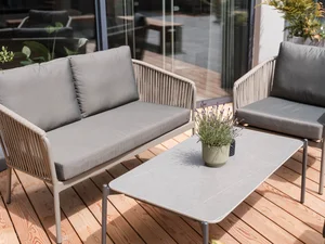 Gemütliche Loungesitzecke auf der Terrasse Moderne Sitzgruppe mit Sofa, Sessel, Tisch und Pflanze auf einer Holzterrasse im Zeller’s Quartier.