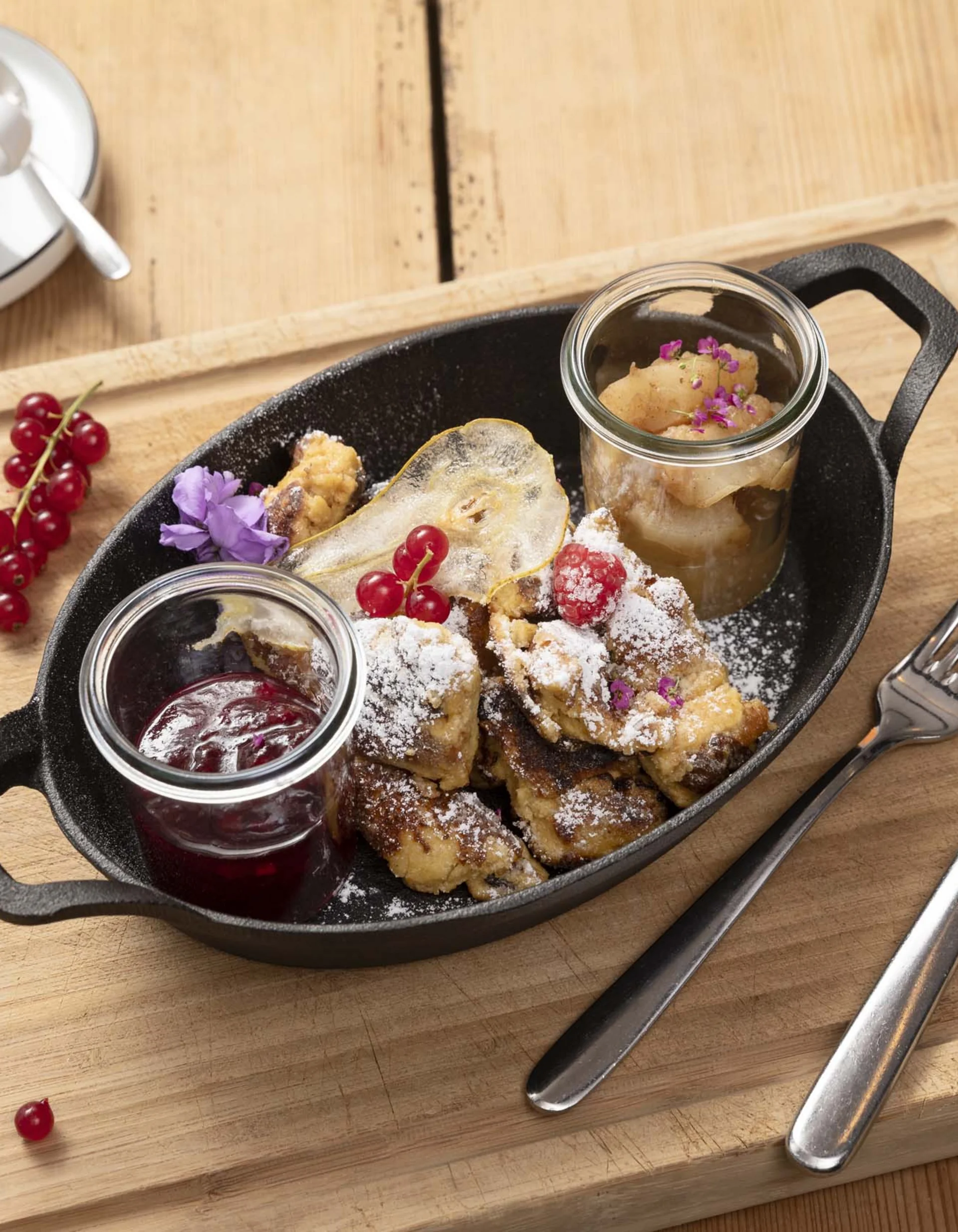 Kaiserschmarrn mit Kompott und Kaffee auf Holzbrett mit Besteck