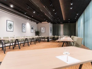 Zeller’s Quartier: das besondere Tagungshotel in Bayern Moderner Konferenzraum mit U-förmigen Tischen und grünen Stühlen