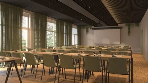 Bright seminar room with green chairs, tables, and projector screen