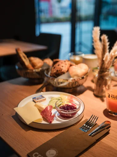 Vorspeise mit Käse, Salami, Dressing und Brot auf Holztisch im Restaurant