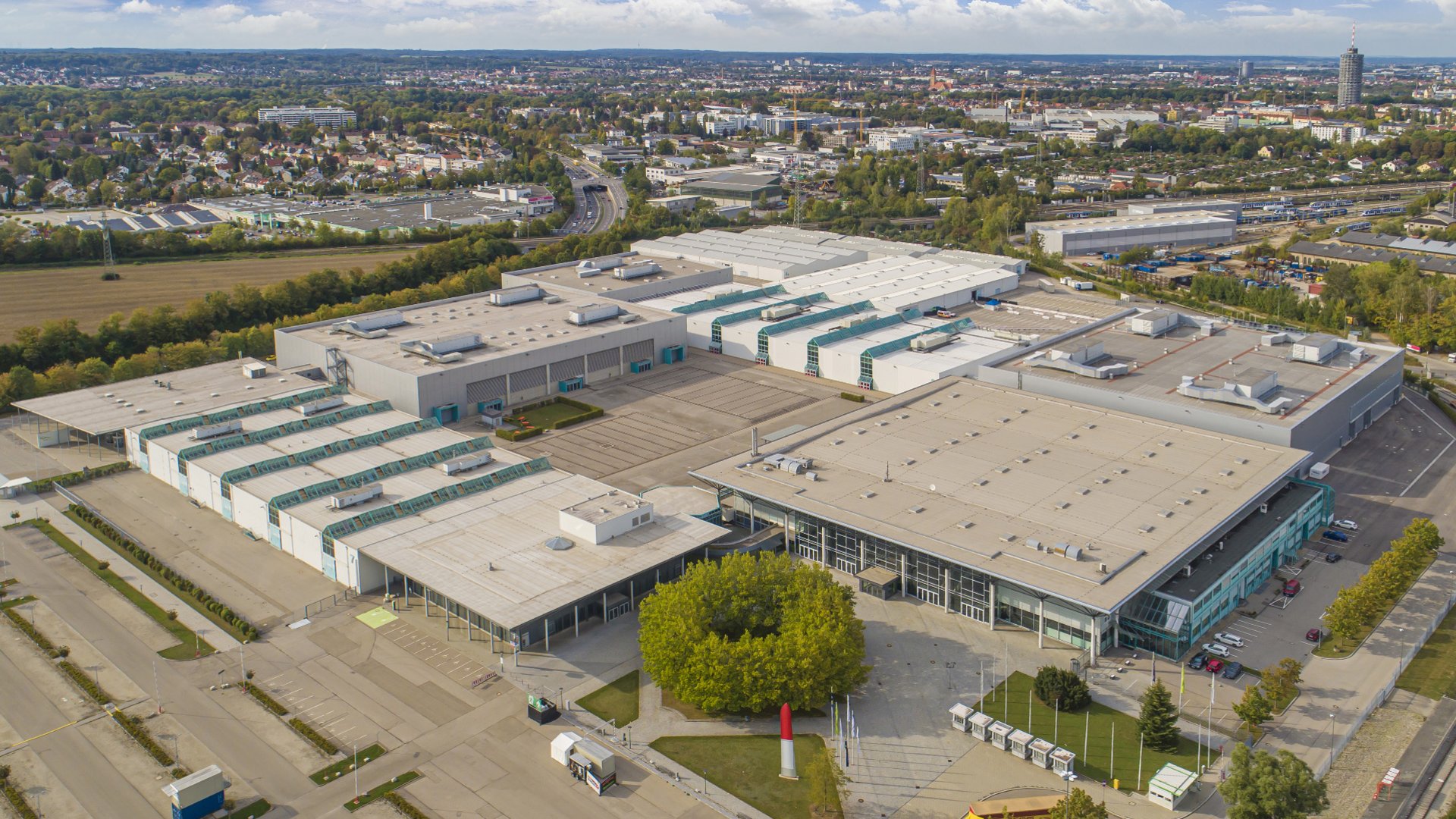 Luftaufnahme eines großen Industriegeländes mit mehreren Gebäuden und Parkplätzen