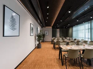 Zeller’s Quartier: das besondere Tagungshotel in Bayern Moderner Speisesaal mit Pflanzen und gerahmten Pflanzenbildern an der Wand