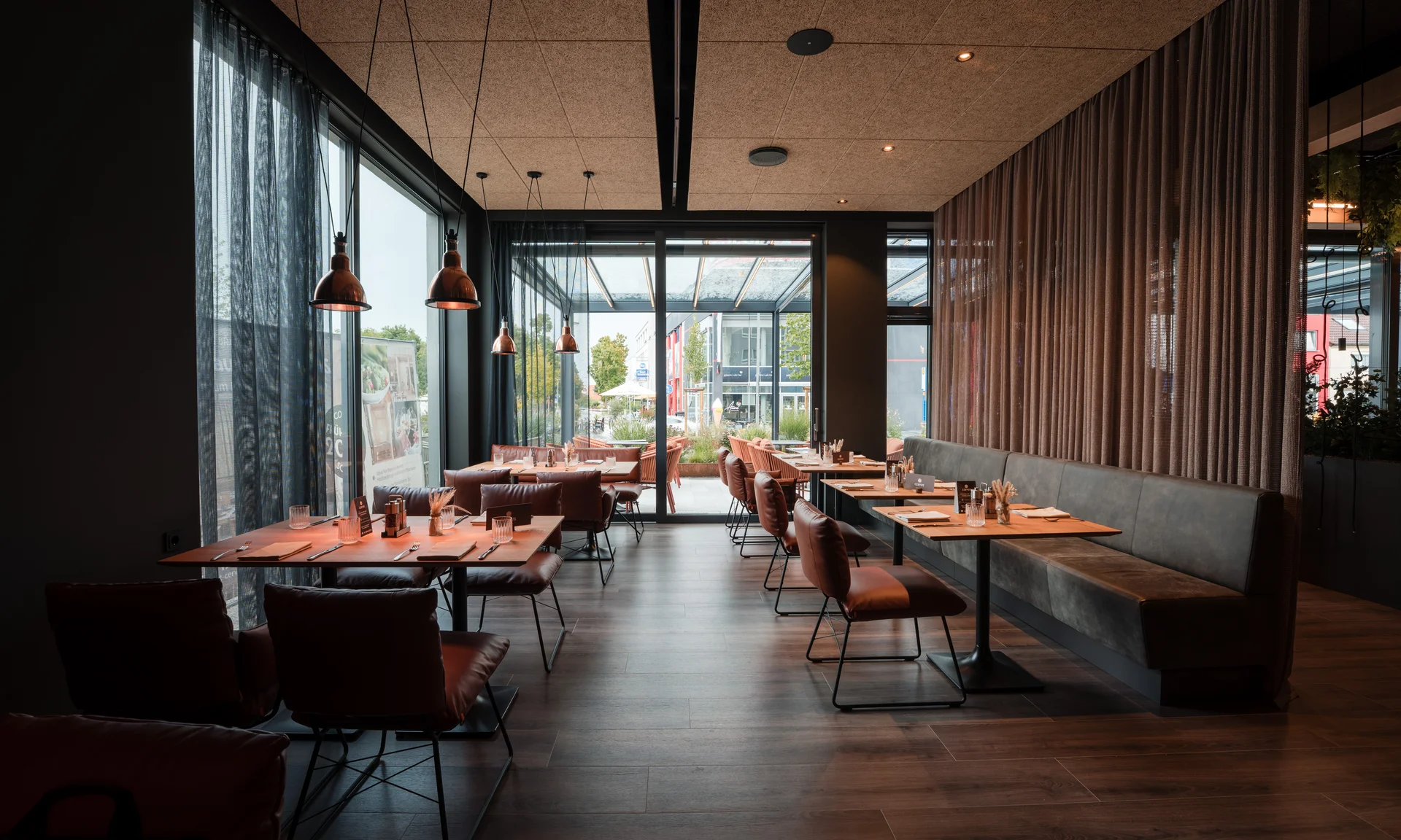 Modernes Restaurant mit braunen Stühlen, Holztischen und großen Fenstern