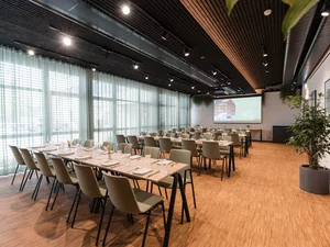 Zeller’s Quartier: das besondere Tagungshotel in Bayern Moderner Konferenzraum mit langen Tischen, Stühlen und Projektor